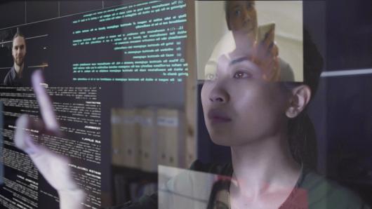 woman surrounded by technology and screen reflections