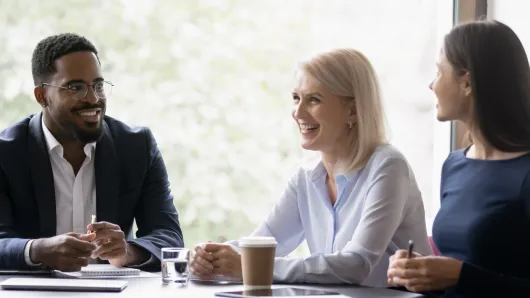 group of professionals sitting around a table, engaged in discussion