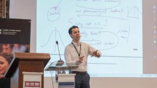 Program Director, Felipe Fregni, MD standing in front of a podium teacing