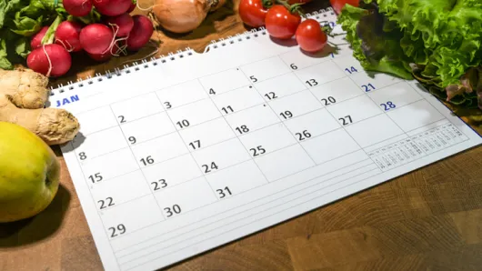 Calendar surrounded by vegetables. 