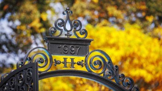 Harvard's holworthy gate framed by yellow leaves.