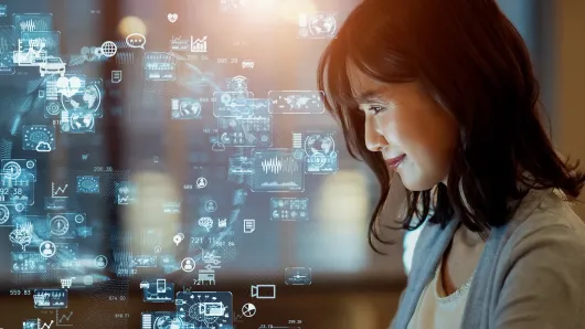 woman viewing holographic data and AI icons on a digital interface