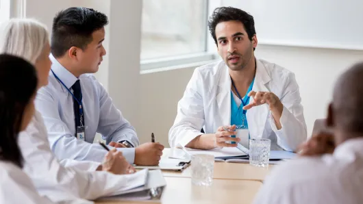 A health care provider speaking to colleagues.