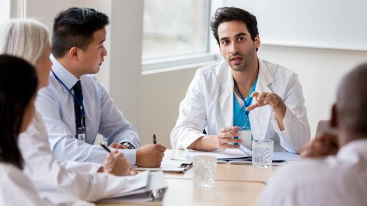A health care provider speaking to colleagues.