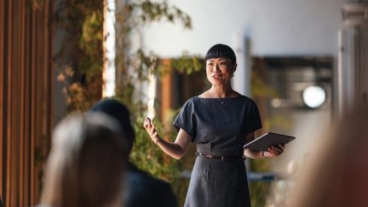 A woman speaking to a room.