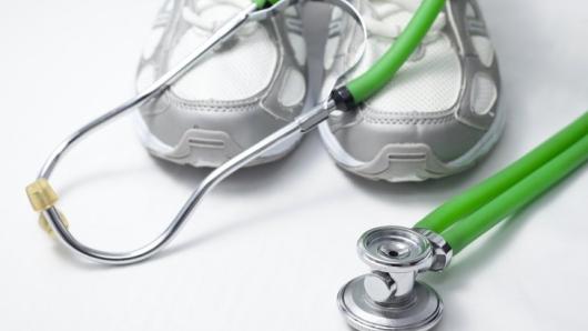 A stethoscope laying across sneakers.