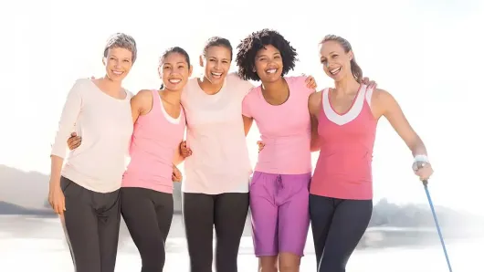 Women standing in a group smiling.