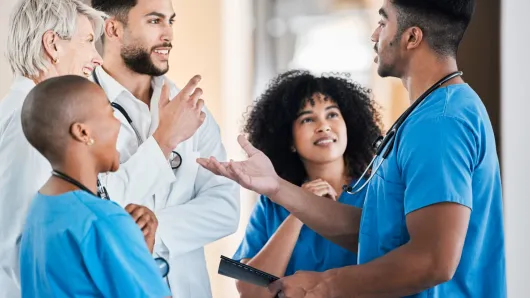 Health care workers standing in a circle chatting