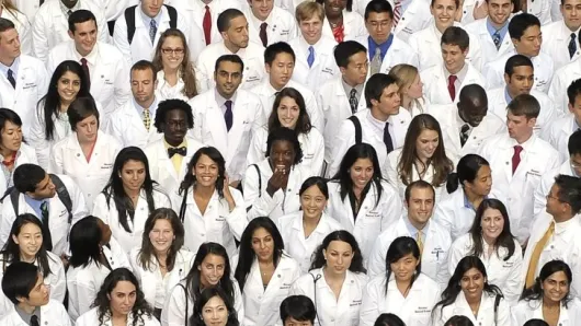 Crowd of new medical students looking up at camera.