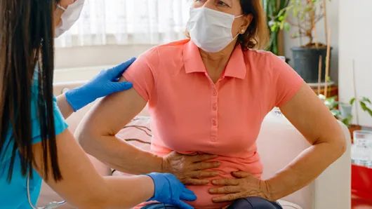 Abdominal pain patient woman having medical exam with doctor.