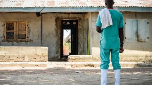 A health worker in front of a clinic.