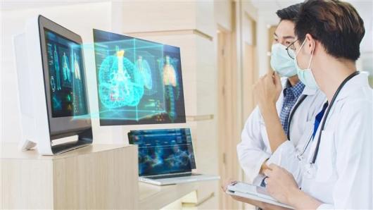 Two masked health care workers looking at AI images on a computer screen