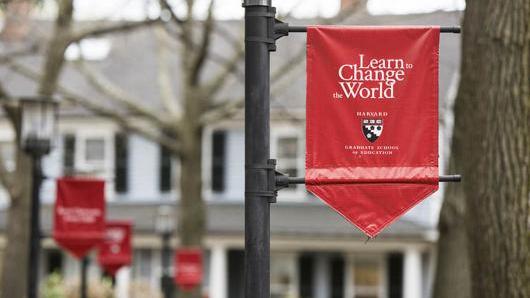 HGSE Banner hanging in a courtyard reads Learn to Change the World
