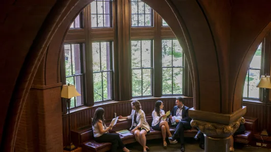 Master Class participants engage in negotiation role plays in front of windows at Harvard Law School.