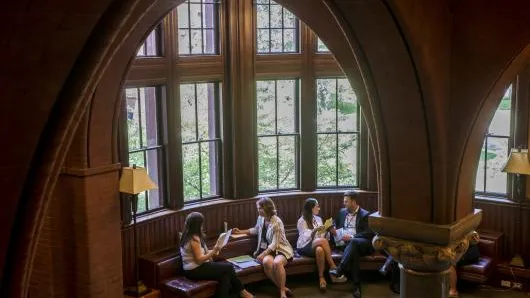 Master Class participants engage in negotiation role plays in front of windows at Harvard Law School.