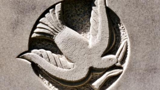 Stone carving showing a dove holding an olive branch in its beak