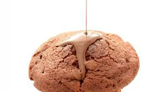 chocolate muffin with liquid chocolate being poured over it