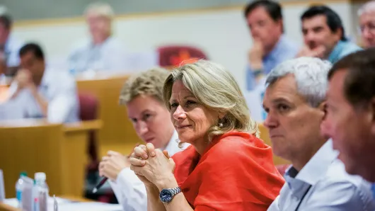 Close up of a diverse group of executives in a HBS classroom