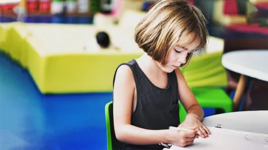 A girl writing at a desk.