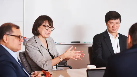 Female executive talking with 3 male executives