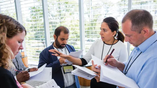 Female executive leading a discussion with another female executive and two male executives