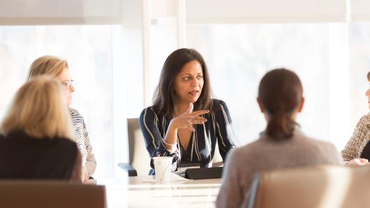 A diverse group of women at a conference table having a discussion