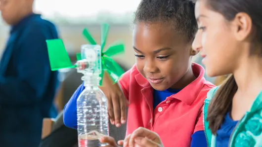 Young learners make a windmil out of a waterbottle.